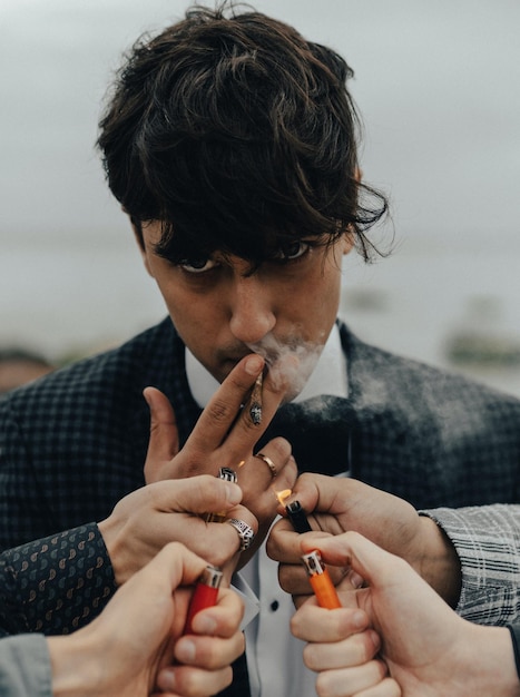 Photo homme allumant une cigarette avec une cigarette à la main