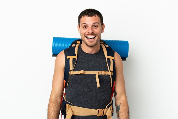 Homme d'alpiniste brésilien avec un gros sac à dos sur fond blanc isolé avec une expression faciale surprise