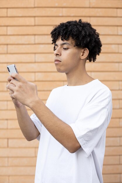 Homme américain tenant un téléphone et écrivant un message sous une photo sur un site de réseautage social