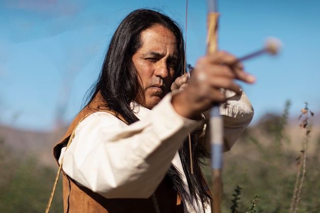 Photo homme amérindien utilisant un arc et une flèche