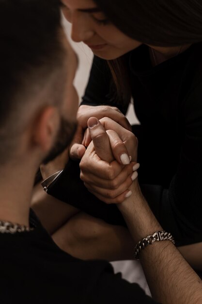 Homme amoureux câlin et embrasse sa petite amie dans une maison confortable Jeune famille passant du temps ensemble Sentiments et amour Histoire d'amour d'un beau jeune couple passant du temps ensemble à la maison sur le canapé