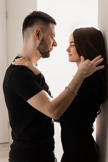 Homme amoureux câlin et embrasse sa petite amie dans une maison confortable Jeune famille passant du temps ensemble Sentiments et amour Histoire d'amour d'un beau jeune couple passant du temps ensemble à la maison sur le canapé