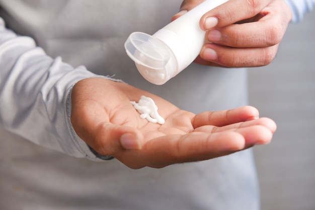 homme appliquant une crème de beauté sur la peau