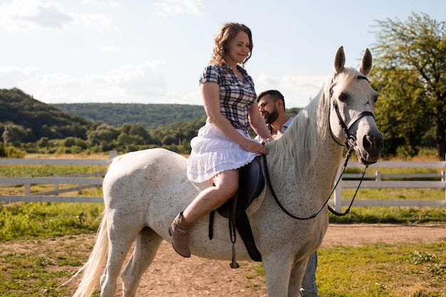 L'homme apprend à une femme à monter à cheval