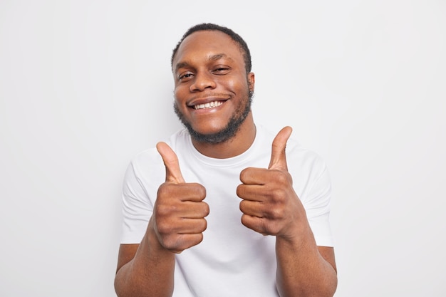 l'homme approuve une promo incroyable garde le pouce levé aime et accepte d'être satisfait de quelque chose porte des vêtements décontractés fait l'éloge du travail cool isolé sur blanc