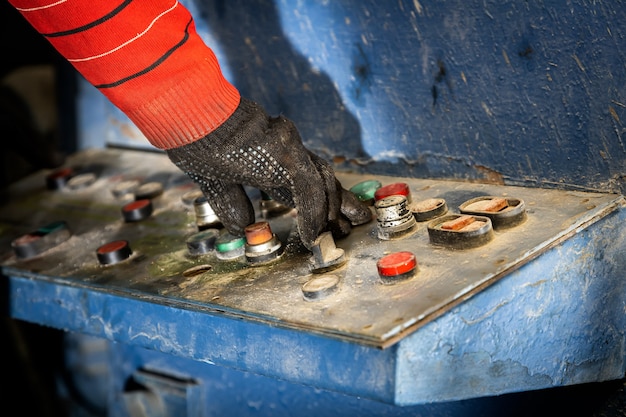 Homme en appuyant sur les boutons du panneau de commande à l'usine