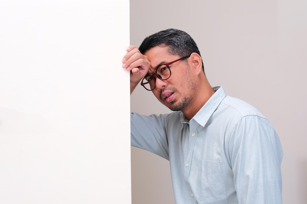 Un homme appuyant sa tête sur le mur montrant son regret