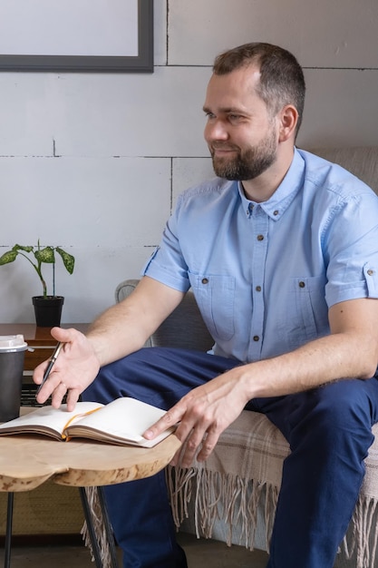 Un homme arabe d'âge moyen dans un costume d'affaires parlant à une table de café Homme d'affaires souriant écrivant des notes dans son journal personnel