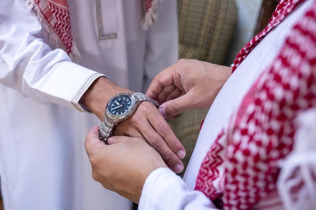 Un homme arabe donne à son ami arabe une montre-bracelet