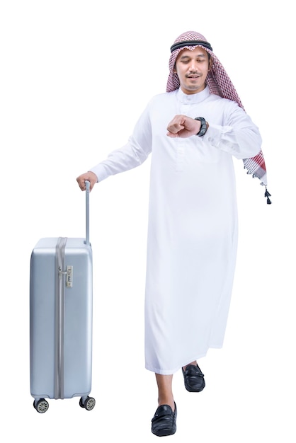 Homme arabe portant un keffieh regardant la montre à son poignet avec une valise pour voyager