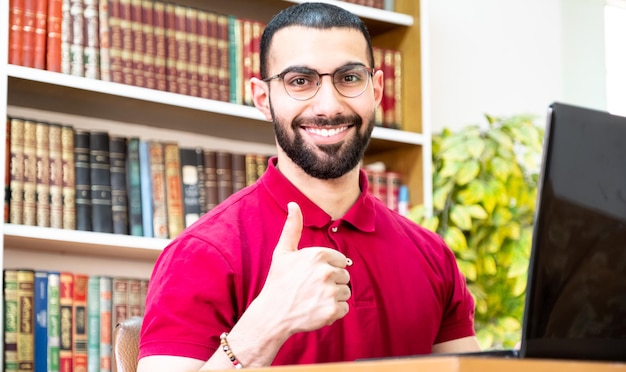 Homme arabe utilisant un ordinateur portable pendant ou lors de réunions pour étudier et enseigner via des canaux en ligne