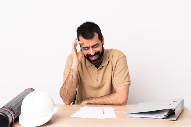 Homme architecte caucasien avec barbe dans une table en riant