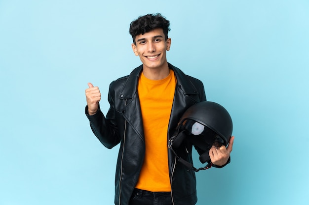 Homme argentin avec un casque de moto pointant sur le côté pour présenter un produit