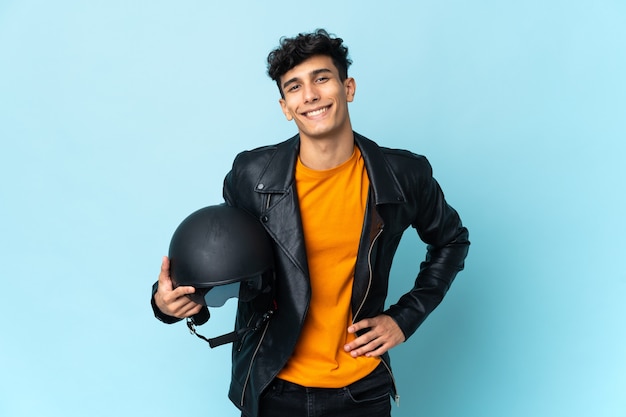 Homme argentin avec un casque de moto posant avec les bras à la hanche et souriant