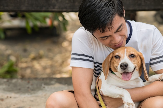 Homme asiatique adorable mignon jouant avec son animal de compagnie chiot, Beagle est un chien amical avec l'homme.