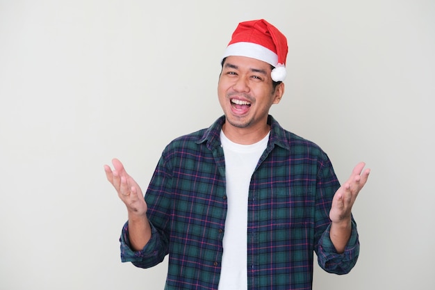 Homme asiatique adulte portant un chapeau de noël avec une expression excitée