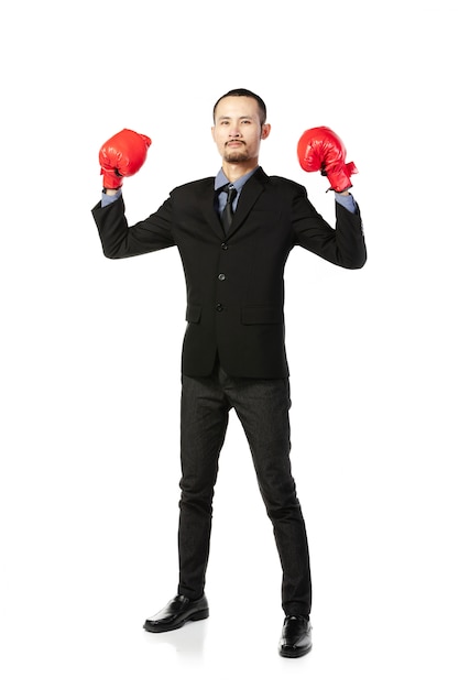 Homme asiatique d'affaires prêt à se battre avec des gants de boxe.
