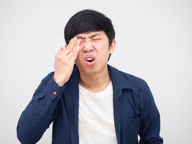 L'homme asiatique a blessé son fond blanc de portrait de visage de douleur d'oeil