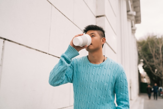 Homme asiatique buvant une tasse de café.