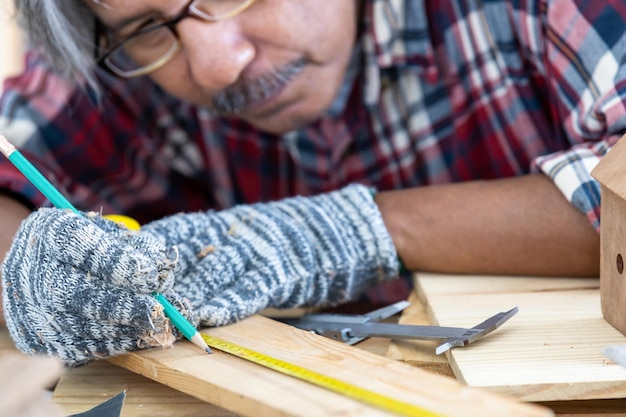 Homme asiatique charpentier travaillant sur le travail du bois dans un atelier de menuiserie Charpentier travaillant sur l'artisanat du bois à l'atelier matériaux de construction meubles en bois