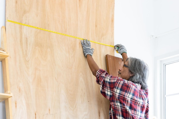 Homme asiatique charpentier travaillant sur le travail du bois dans un atelier de menuiserie Charpentier travaillant sur l'artisanat du bois à l'atelier matériaux de construction meubles en bois