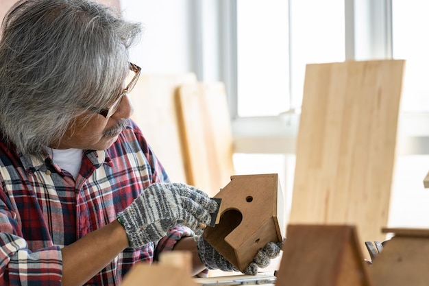 Homme asiatique charpentier travaillant sur le travail du bois dans un atelier de menuiserie Charpentier travaillant sur l'artisanat du bois à l'atelier matériaux de construction meubles en bois