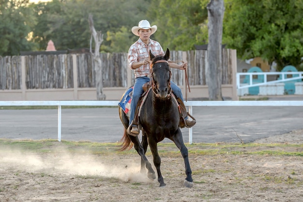 Homme asiatique à cheval dans la ferme.