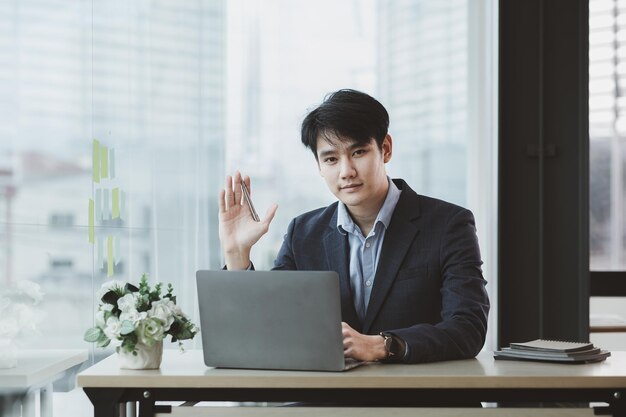 Homme asiatique avec costume jeune homme d'affaires en tant que PDG d'une startup salle de direction jeunes dirigeants d'une startup dirigés par de jeunes leaders Concept de gestion des startups et des hommes d'affaires