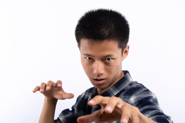 Un homme asiatique dans une chemise à carreaux fait des mouvements amusants avec les deux mains