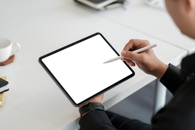 Homme asiatique dessinant sur une tablette d'ordinateur à écran blanc vierge avec stylet