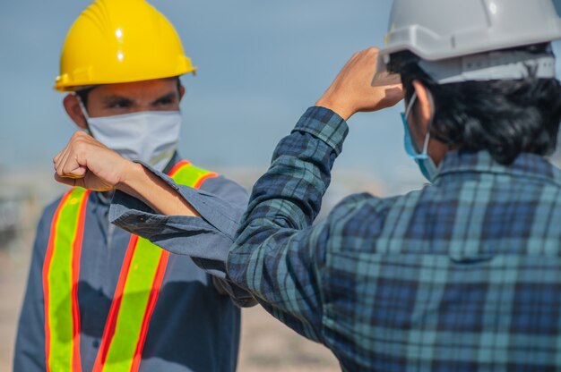 Homme asiatique deux personnes ingénieur serrent la main nouvelle normale sur la construction du site