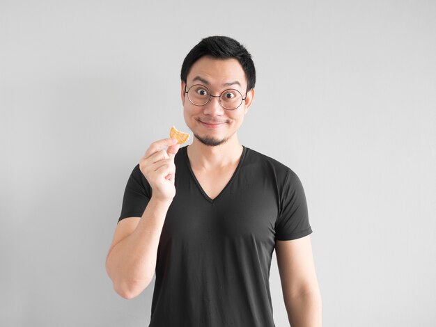 Homme asiatique drôle montrant comment manger des biscuits d&#39;une manière heureuse.