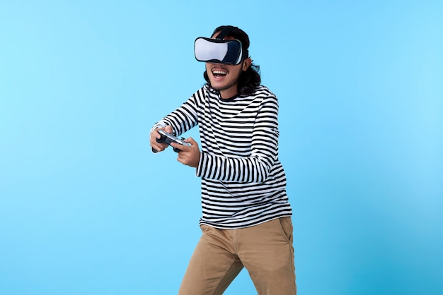 Homme asiatique excité portant des lunettes 3d jouant au jeu vidéo sur l'espace bleu.