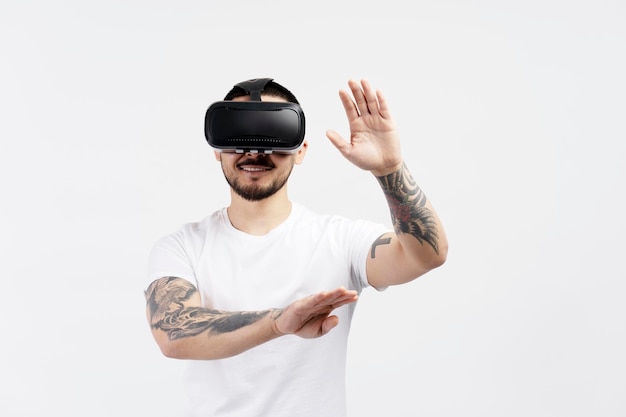 Homme asiatique excité avec un tatouage élégant à l'aide de lunettes de réalité virtuelle jouant à un jeu vidéo