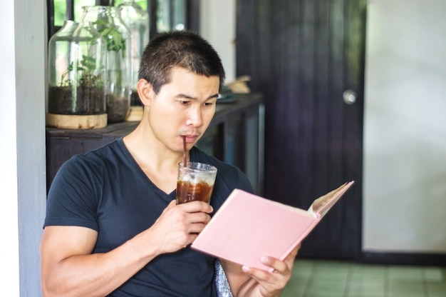 L&#39;homme asiatique a lu le livre dans le café.