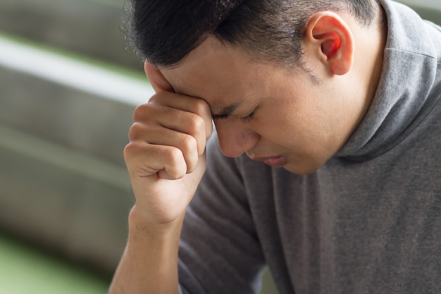 Homme asiatique malade ayant mal à la tête, stress