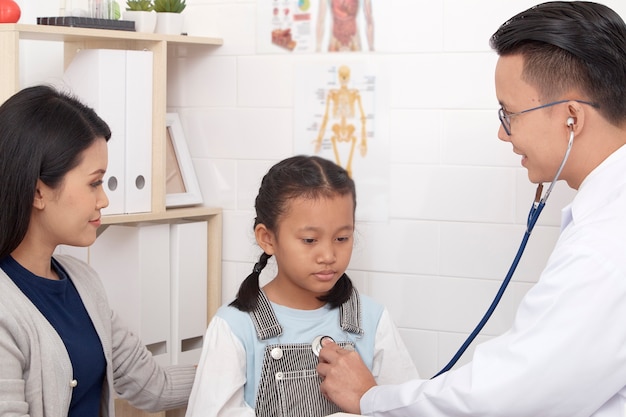 Homme asiatique médecin parlant à un jeune enfant et à sa mère Concepts de prévention et de soins de santé