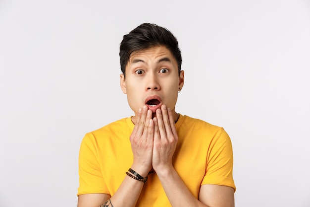 Homme asiatique mignon en t-shirt jaune avec la bouche ouverte