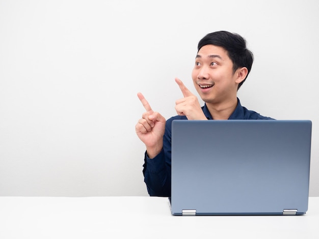 Homme asiatique avec ordinateur portable sourire et pointer le doigt sur l'espace de copie fond blanc