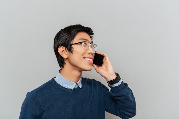 Homme asiatique parlant au téléphone. avec des lunettes