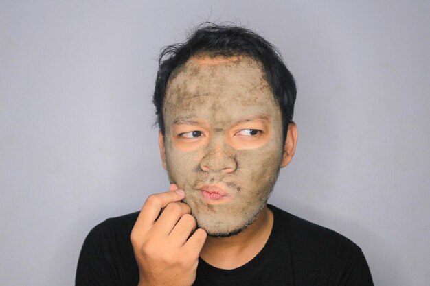 Un homme asiatique pensait et rêvait lorsqu'il utilisait un masque de beauté