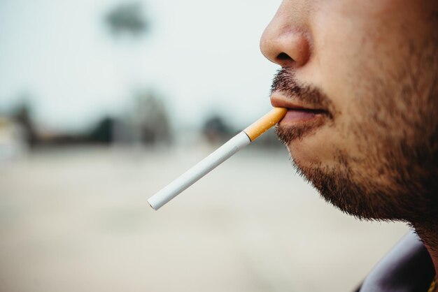 Homme asiatique portant une cigarette à la bouche attendant d'être smokeno journée mondiale du tabac