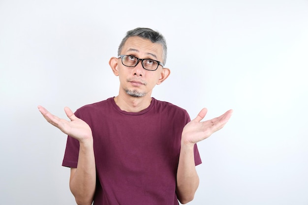 Homme asiatique portant des vêtements décontractés désemparés et confus avec les bras ouverts aucune idée et visage douteux