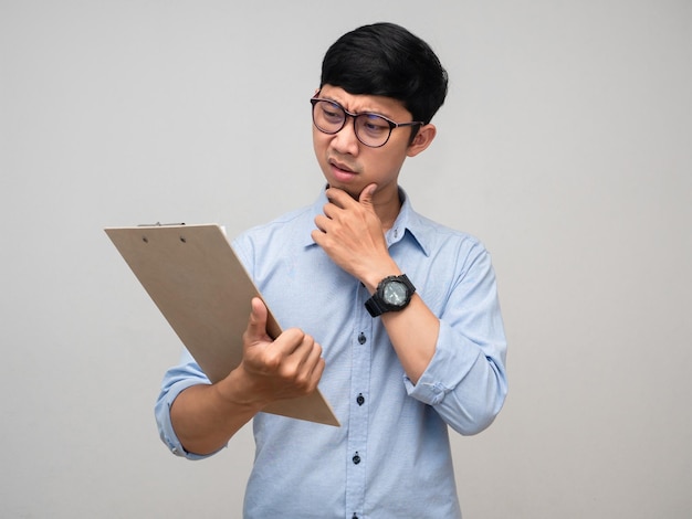 Un homme asiatique porte des lunettes réfléchies avec la lecture du tableau de documents à la main isolé