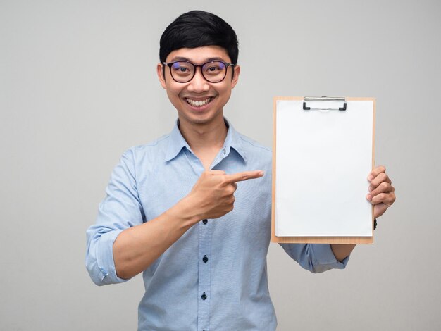 Homme asiatique positif porter des lunettes sourire et pointer du doigt le tableau de document vierge isolé