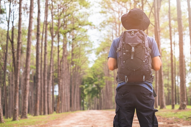 Homme asiatique avec sac à dos de randonnée en forêt