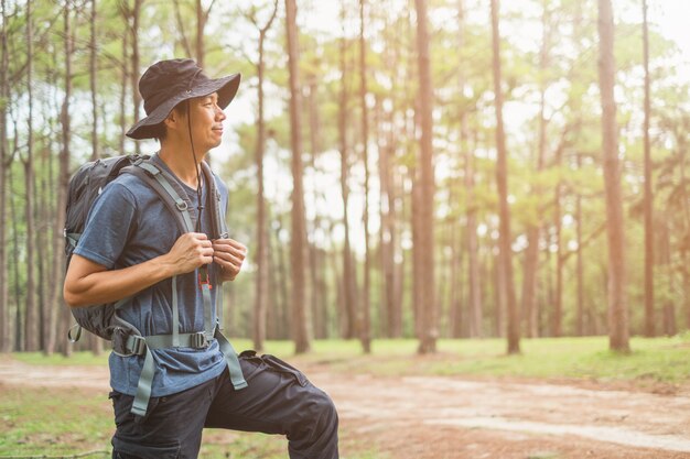 Homme asiatique avec sac à dos de randonnée en forêt