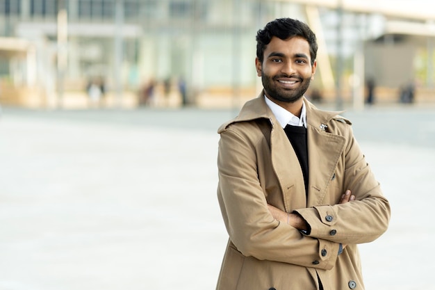 Homme asiatique souriant confiant portant un trench-coat élégant avec les bras croisés regardant la caméra