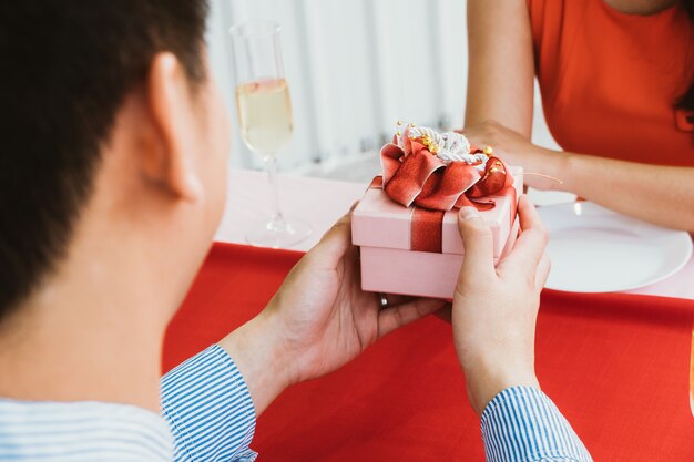 Homme asiatique surprend sa petite amie avec une boîte cadeau romantique