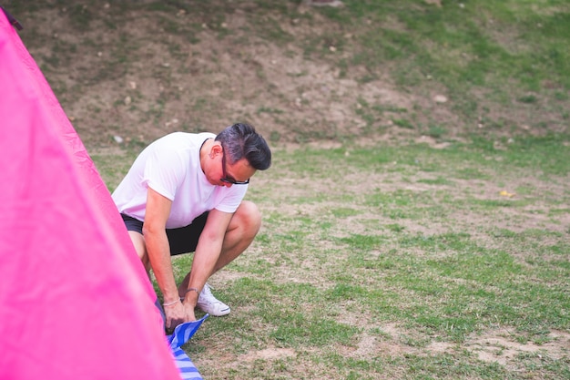 Un Homme Asiatique En T-shirt Blanc Réglage Tente Rose Au Camping